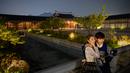 Pengunjung mengenakan gaun tradisional Korea, hanbok sambil berpose saat kunjungan malam ke Istana Gyeongbokgung di Seoul, 4 Oktober 2019. Kunjungan malam tersedia pada minggu ketiga dan keempat setiap bulan mulai dari 26 April sampai 31 Oktober, kecuali pada bulan Agustus. (Photo by Ed JONES / AFP)