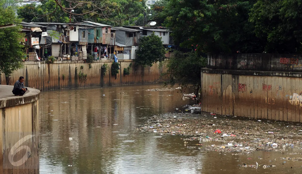 Warga memancing di Kali Krukut dekat TPU Karet Bivak Jakarta, Sabtu (5/11). Tumpukan sampah terlihat menggenang di sisi aliran Kali Krukut dan berbau. (Liputan6.com/Helmi Fithriansyah)