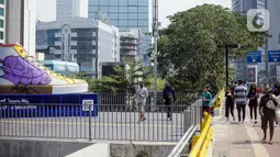 Suasana di sekitar Tugu Sepatu, Sudirman, Jakarta, Minggu (19/9/2021). Tugu Sepatu menjadi sasaran pencoretan dengan semprotan aerosol oleh orang tak dikenal sehari usai diresmikan pada 17 September 2021. (Liputan6.com/Faizal Fanani)