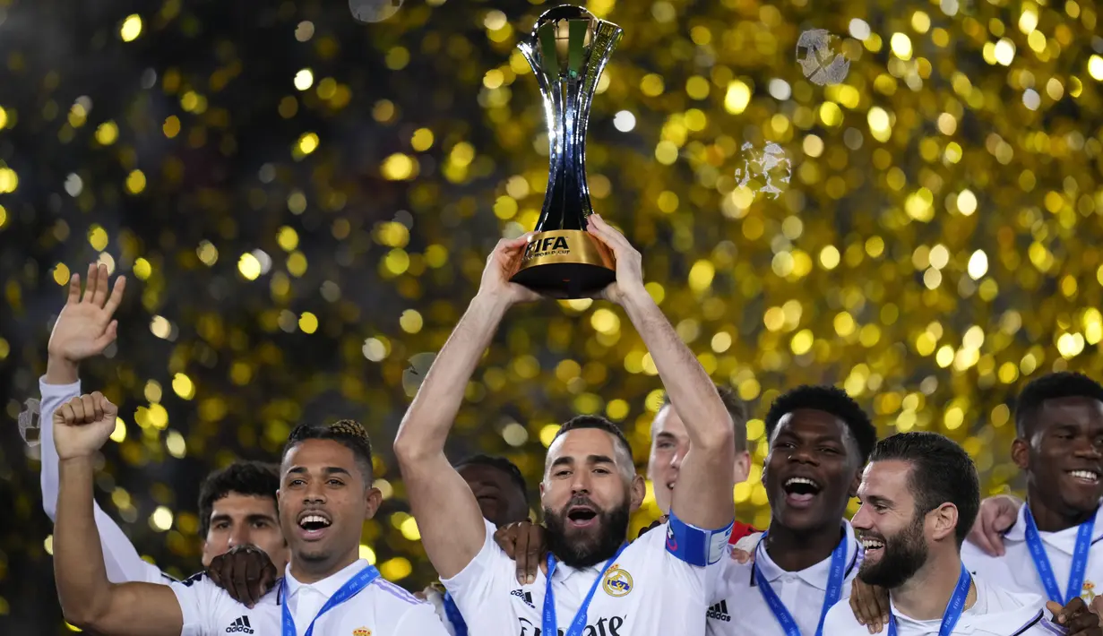 Penyerang Real Madrid Karim Benzema memegang trofi Piala Dunia Antarklub 2022 saat berselebrasi dengan rekan setimnya usai mengalahkan Al Hilal dalam laga final di Prince Moulay Abdellah Stadium, Rabat, Minggu (12/2/2023) dini hari WIB. Sebelumnya, Real Madrid sukses menyabet trofi juara pada edisi 2014, 2016, 2017, dan 2018. (AP Photo/Manu Fernandez)