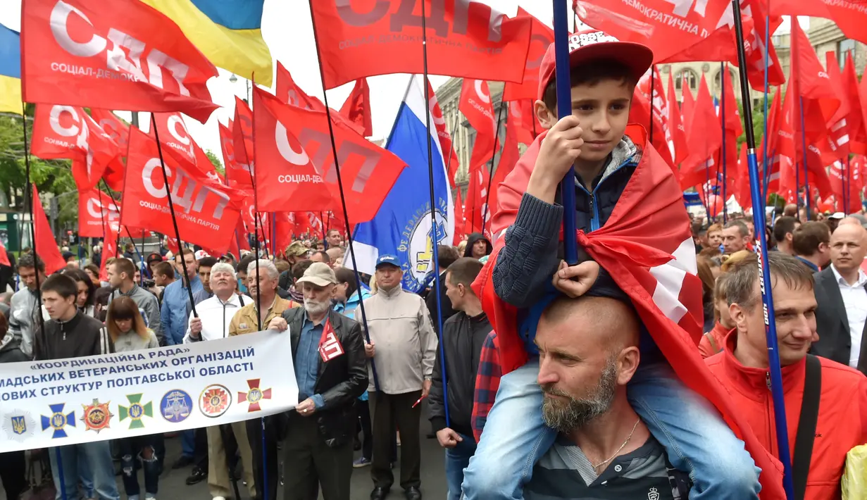 Seorang anak ikut berpartisipasi selama unjuk rasa peringatan May Day di Kiev, Ukraina, Senin (1/5). Pekerja di berbagai belahan dunia mengadakan aksi Hari Buruh Internasional dengan memadati jalan-jalan besar menyuarakan aspirasi. (Sergei SUPINSKY/AFP)