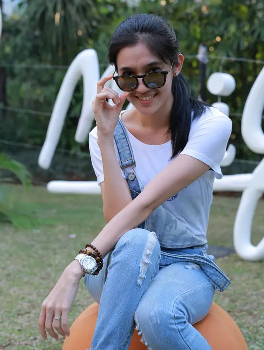 Selain melindungi mata, kacamata pun berguna sebagai penunjang gaya berpakaian Dhini Aminarti. (Galih W.Satria/Bintang.com)