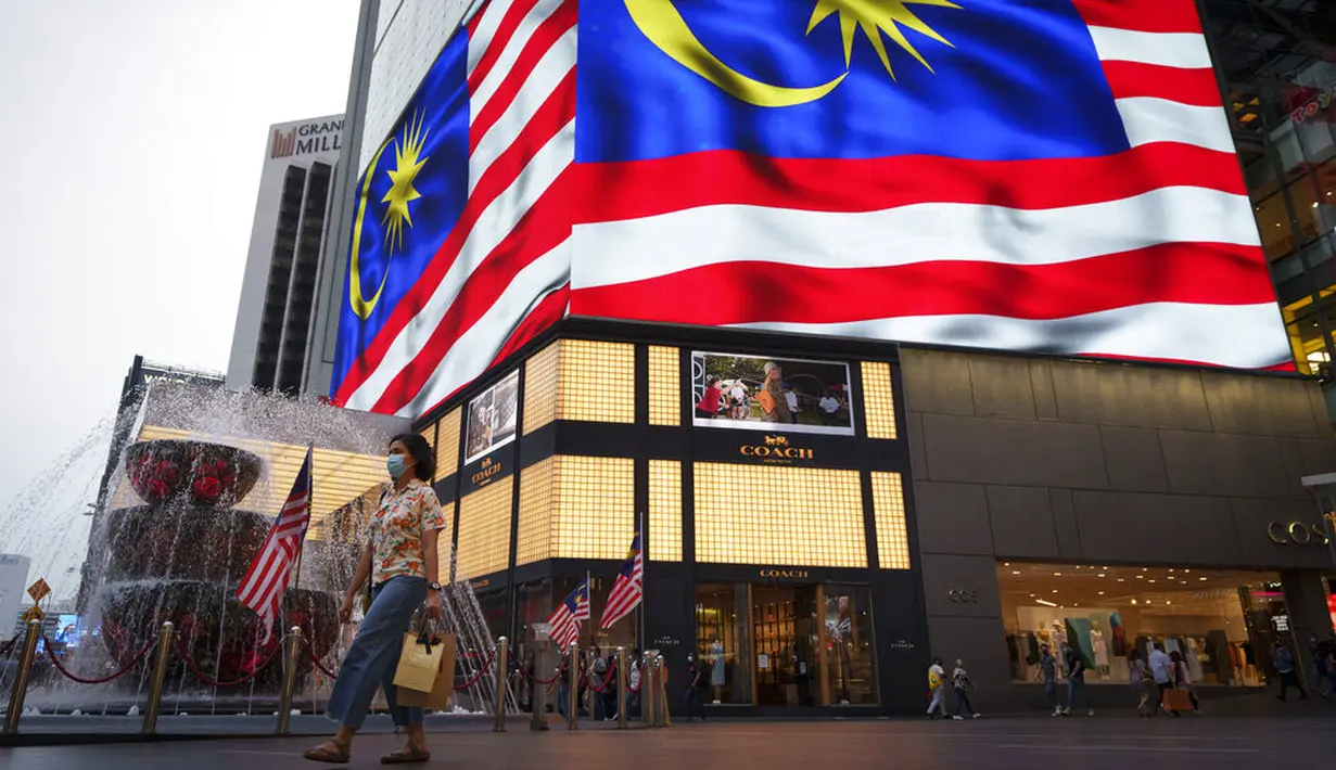Orang-orang yang memakai masker menyeberang jalan di luar pusat perbelanjaan, di tengah wabah COVID-19 di Kuala Lumpur, Malaysia, Selasa (14/9/2021). Baru-baru ini, varian Mu atau B.1621 disebut sudah terdeteksi di Malaysia. (AP Photo/Vincent Thian)