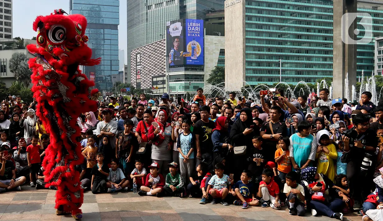 Warga menyaksikan pertunjukkan barongsai saat ajang car free day (CFD) di kawasan Bundaran HI Jakarta, Minggu (26/1/2020). Barongsai tersebut sengaja dihadirkan dalam rangka perayaan Imlek 2020 untuk menghibur para warga yang tengah mengikuti CFD. (Liputan6.com/Johan Tallo)