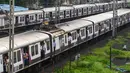 Penumpang berdiri pada pintu gerbong kereta yang terbuka saat mereka melakukan perjalanan dengan kereta lokal di Mumbai, India, Kamis (8/9/2022). (Indranil MUKHERJEE/AFP)