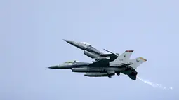 Aksi dua jet tempur F-16 Angkatan Udara Singapura melakukan manuver di udara jelang Singapore Airshow 2018, Jumat (2/2) . Singapore Airshow 2018 akan dihadiri delegasi pemerintah dan militer tingkat tinggi dari seluruh dunia. (AP Photo/Wong Maye-E)