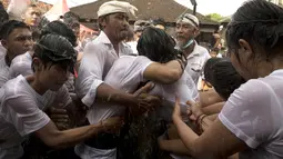 Sepasang remaja berpelukan selama tradisi Omed-omedan (cium-ciuman) di Denpasar, Bali, Jumat (4/3/2022). Tradisi Omed-omedan dilakukan sehari setelah Hari Raya Nyepi saat Ngembak Geni yang digelar sebagai wujud tolak bala. (AP Photo/Firdia Lisnawati)