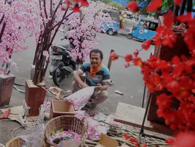 Pengrajin Pohon Hias Imlek menyelesaikan pekerjaannya di kawasan Glodok, Jakarta, Kamis (21/1/2016). Pembeli dapat memesan sesuai keinginan dengan kisaran harga 50.000 - 3.500.000 rupiah. (Liputan6.com/Gempur M Surya)