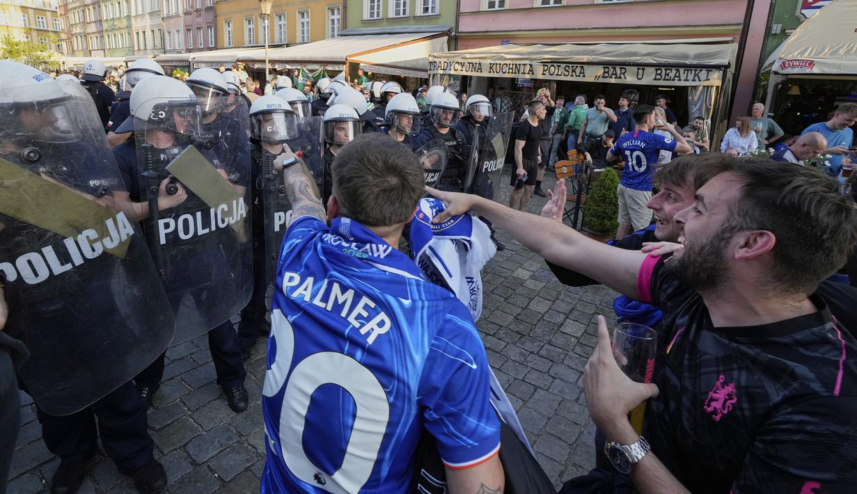 Para polisi terlibat kericuhan dengan para fans menjelang laga final Conference League 2024/2025 antara Real Betis melawan Chelsea di sekitar restoran kota Wroclaw, Polandia, Selasa (27/05/2025) waktu setempat. (AP Photo/Czarek Sokolowski)