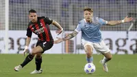 Gelandang AC Milan, Ismael Bennacer (kiri) berebut bola dengan striker Lazio, Ciro Immobile dalam laga lanjutan Liga Italia 2020/2021 pekan ke-33 di Olimpico Stadium, Roma, Senin (26/4/2021). AC Milan kalah 0-3 dari Lazio. (AP/Gregorio Borgia)