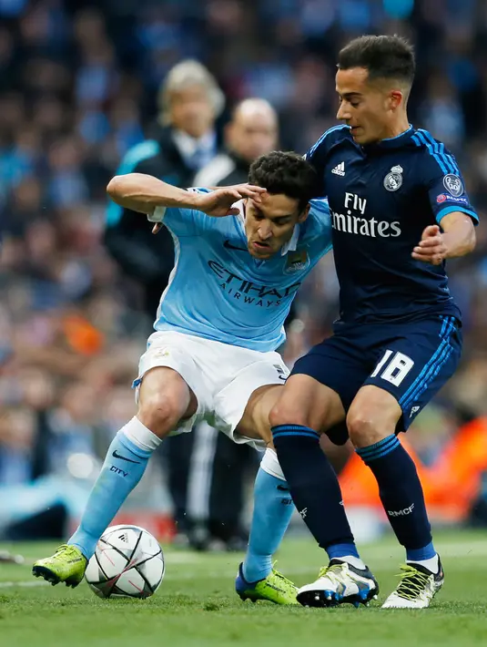 Gelandang City, Jesus Navas (kiri) mengontrol bola dari kawalan penyerang Lucas Vazquez pada leg pertama Semifinal Liga Champions di stadion Etihad, Inggris, (27/4). Real Madrid bermain imbang dengan City dengan skor 0-0. (Reuters/Phil Noble)