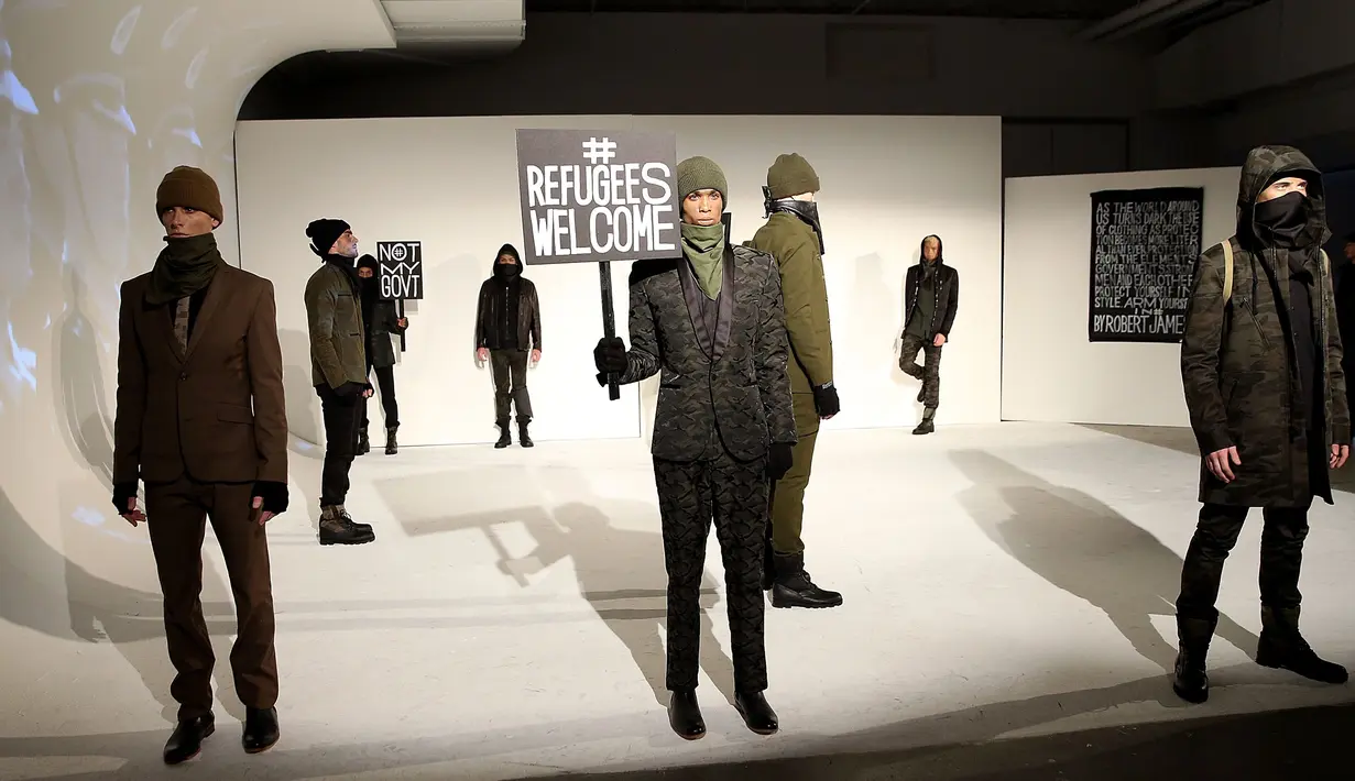  Sejumlah model berpose dengan poster #Refugees Welcome saat presentasi karya desainer Robert James dalam NYFW di New York, AS  (30/1). Presentasi ini menampilkan poster-poster yang menyindir kebijakan Donald Trump. (Robin Marchant Getty Images/AFP)
