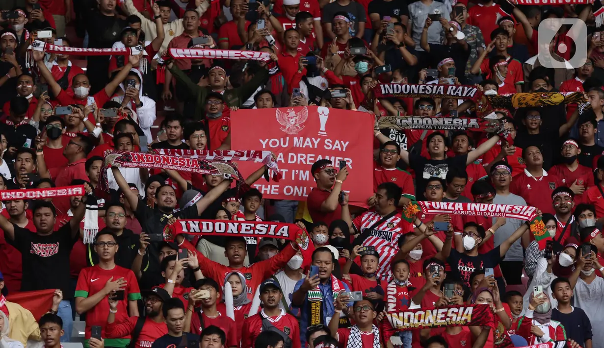 Pendukung timnas Indonesia membentang syal saat menyaksikan laga kualifikasi Grup A Piala AFF 2022 antara Indonesia melawan Kamboja di di Stadion Utama Gelora Bung Karno, Jakarta, Jumat (23/12/2022). Indonesia unggul 2-1 atas Kamboja lewat gol yang dicetak Egy Maulana Vikry dan Witan Sulaeman. (Liputan6.com/Helmi Fithriansyah)