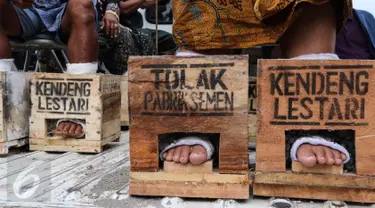 Petani dari kawasan Pegunungan Kendeng melanjutkan aksi protes memasung kaki dengan semen di depan Istana Merdeka, Kamis (16/3). Memasuki hari keempat jumlah mereka bertambah menjadi 39 petani. (Liputan6.com/Fery Pradolo)