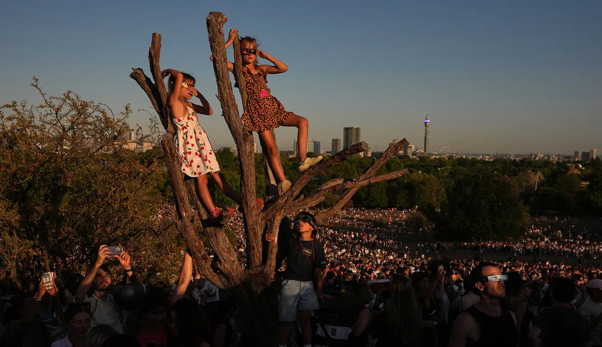 Warga menyaksikan gerhana matahari di Primrose Hill, London, Rabu, 12 Agustus 2026. (Foto AP/Kirsty Wigglesworth)