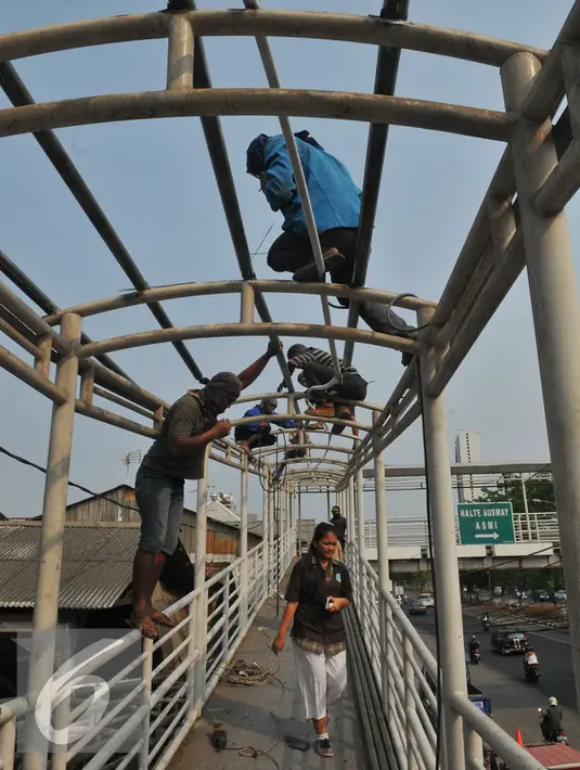 ekerja menyelesaikan perbaikan Jembatan Penyebrangan Orang (JPO) di Jembatan Asmi, Pulo Gadung, Jakarta, Selasa (3/11/2015). Perbaikan itu dilakukan demi menunjang keselamatan dan kenyamanan pengguna jalan. (Liputan6.com/Gempur M Surya)