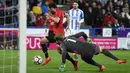 Gelandang Manchester United, Juan Mata berusaha dihadang oleh kiper Huddersfield Town, Jonas Lossl pada pertandingan putaran kelima Piala FA di John Smith's Stadium, Minggu (18/2). MU melaju ke perempatfinal Piala FA setelah menang 2-0. (Oli SCARFF/AFP)