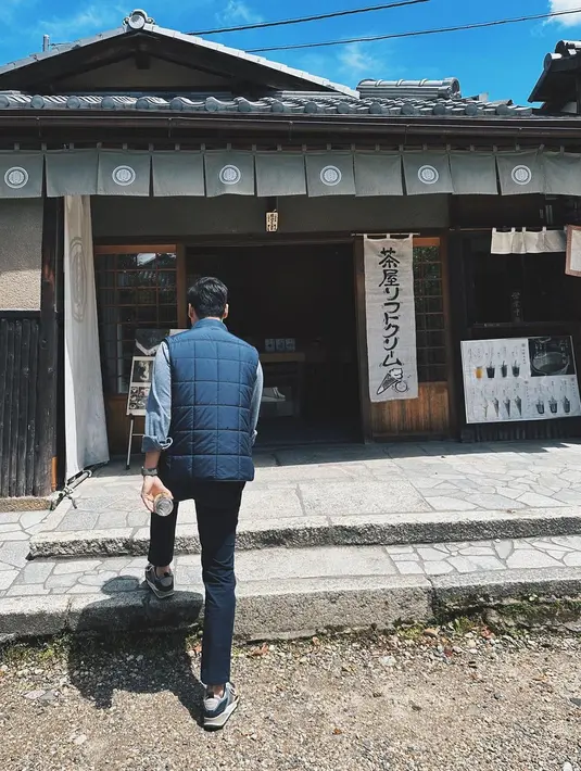 Walaupun dipotret dari belakang, terlihat Jesse Choi kembali memilih tampilan kasual yang chic. Kemeja denim dilapisi dengan puffer vest biru navy dan dipadu dengan celana panjang hitam. Foto: Instagram.