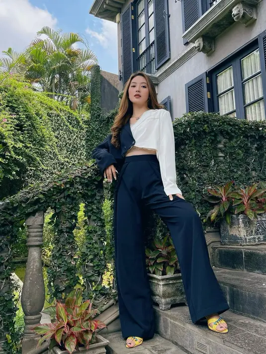 Kali ini Natasha Wilona mengenakan outfit monokrom dengan dominan hitam. Dengan dual tone shirt, Natasha tampil cantik dengan trouser berwarna hitam. Tampilan agak mencolok diaplikasikan pada heels berwarna kuning.