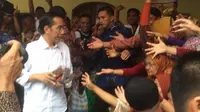 Jokowi membagi kain batik di Masjid Al Qomar Cilacap.