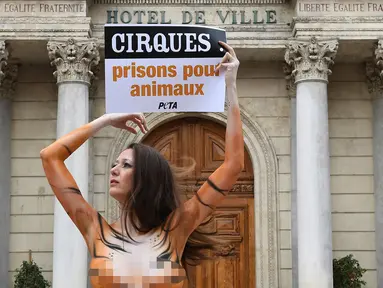 Model asal Brasil, Juliana Marques menunjukkan plakat dengan tulisan "Sirkus, penjara untuk binatang" saat melakukan aksi di Avignon, Prancis (11/2). Aksi tersebut ini untuk menyuarakan penolakannya terhadap pertunjukan sirkus. (AFP Photo / Boris Horvat)