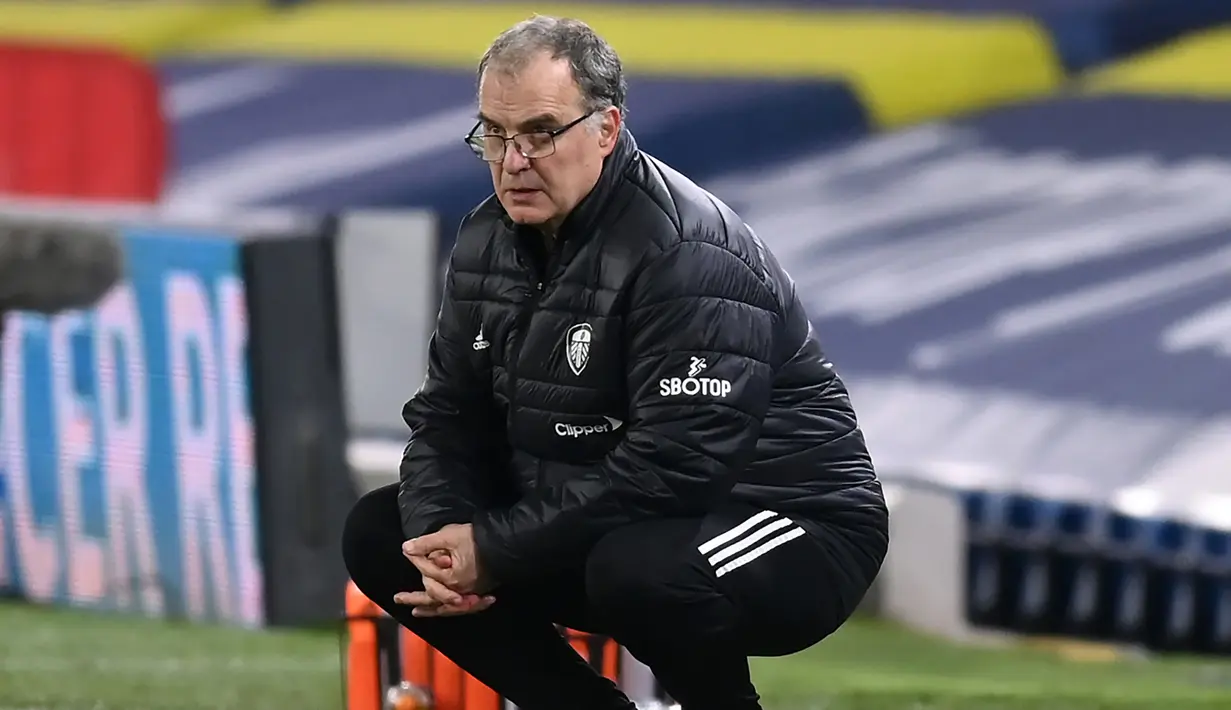Sambil berjongkok, sebagai ciri khasnya, Marcelo Bielsa mengamati penampilan anak buahnya meladeni permainan Arsenal. (AFP/Michael Regan/Pool)