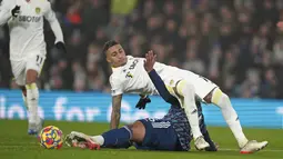 Penyerang Leeds United Raphinha (atas) berebut bola dengan bek Arsenal Gabriel pada pekan ke-18 Liga Inggris di Stadion Ellan Road, Leeds, Minggu (19/12/2021) dini hari WIB. Arsenal menang 4-1 di kandang Leeds United. (AP Photo/Jon Super)