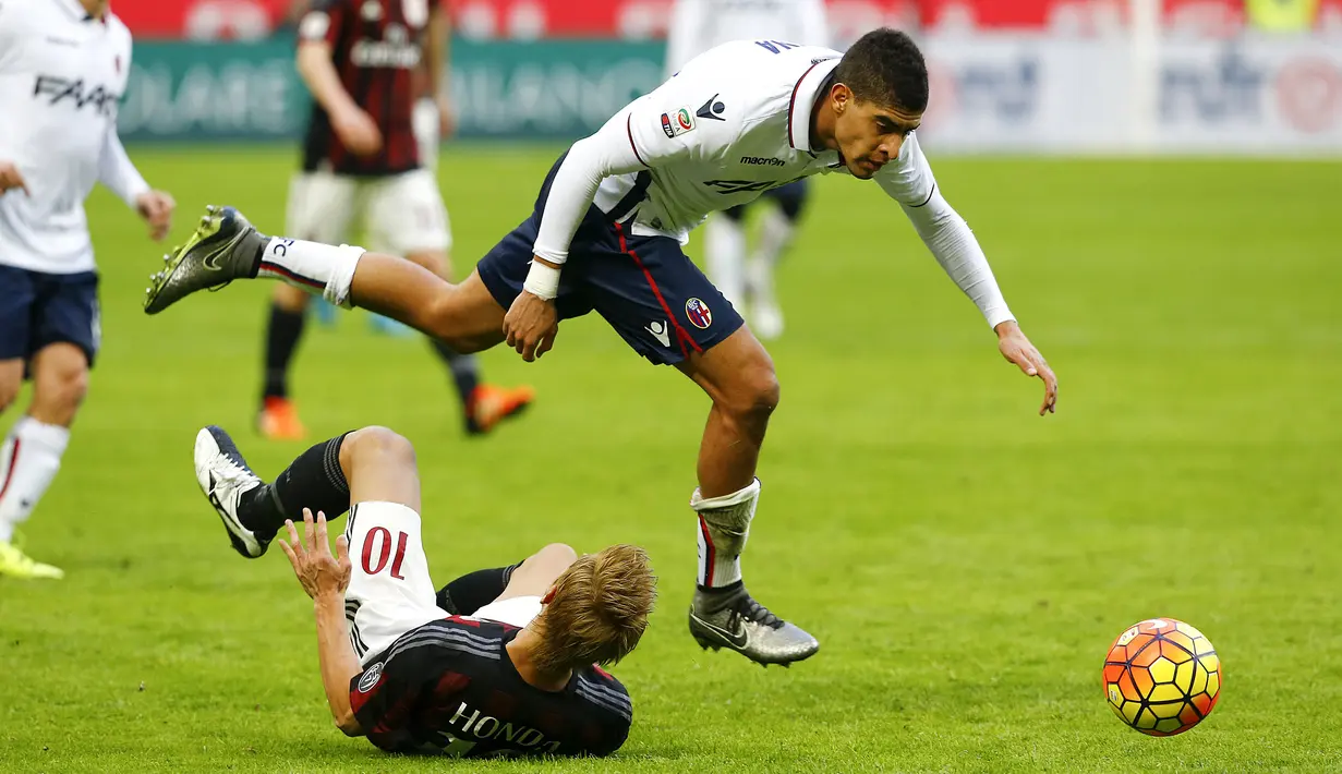 Bek Bologna, Adam Masina (kanan) berusaha mengejar bola dari kawalan gelandang AC Milan, Keisuke Honda pada laga liga italia di Stadion San Siro, Milan, Italia (7/1/2016). Bolagna menang atas AC Milan dengan skor 1-0. (REUTERS/Stefano Rellandini)