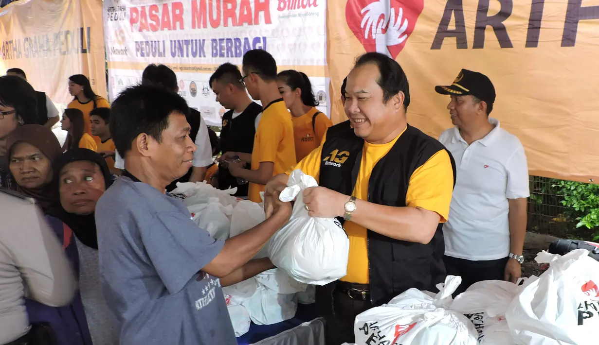 Penyerahan paket sembako murah oleh direktur Bank Artha Graha Andy Kasih kepada warga Sawah Besar, Jakarta, Minggu (24/1/2014). (Media Center AGN - AGP)