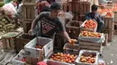 Pedagang menata tomat dagangannya di Pasar Induk Kramat Jati, Jakarta, Selasa (22/12). Jelang Natal dan tahun baru, harga sayur mayur dan beberapa kebutuhan pokok lainnya di beberapa pasar tradisional di Jakarta merangkak naik. (Liputan6.com/Angga Yuniar)