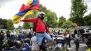 Seorang pengendara sepeda motor mengibarkan bendera selama protes kenaikan harga bahan bakar dan asuransi wajib pihak ketiga di Bogota, Kolombia, Rabu (12/10/2022). Aktivis berkumpul di luar Perpustakaan Virgilio Barco, yang terletak di dekat Simon Bolivar Central Park, mulai pukul 07:30. (AP Photo/Ivan Valencia)