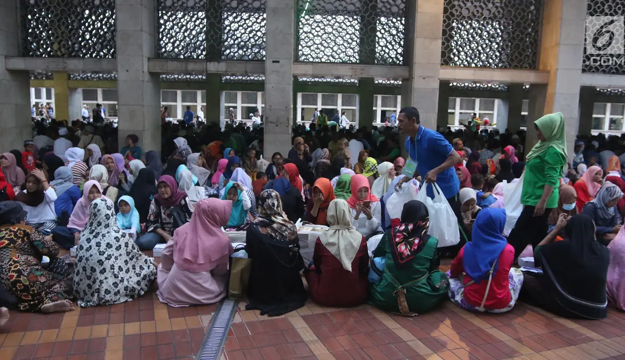 Panitia membagikan paket makanan kepada jemaah wanita yang ingin buka puasa di Masjid Istiqlal, Jakarta, Kamis (17/5). Mereka yang buka puasa di Masjid Istiqlal biasanya adalah tuna wisma, musafir, dan kaum duafa. (Liputan6.com/Arya Manggala)