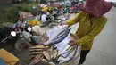 Seorang pedagang menjual ikan di sepanjang trotoar dekat desa Prek Pnov di Phnom Penh, Kamboja, Kamis (5/8/2021). Prek Pnov terkenal dengan peternakan ikannya dan memasok banyak pasar di Phnom Penh. (AP Photo/Heng Sinith)