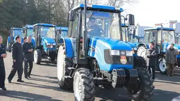 Foto yang dirilis kantor berita KCNA (15/11), Kim Jong-un saat mengendarai traktor di Kumsong Tractor Factory. Kunjungan tersebut dilakukan untuk menunjukkan bahwa ekonomi Korut tak terpengaruh oleh sanksi internasional. (AFP Photo/Kcna Via Kns/Str)