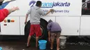Suporter Persija, Jakmania, mencuci bus transjakarta di kantor PT Transjakarta, Jakarta, Kamis (13/12). Hal tersebut bentuk tanggung jawab atas aksi vandalisme oknum suporter saat Persija meraih Juara Liga 1 2018. (Liputan6.com/Immanuel Antonius)