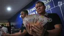Petugas menunjukan uang palsu saat rilis oleh Direktorat Tindak Pidana Ekonomi Khusus Bareskrim Polri di Jakarta, Rabu (18/10). Uang palsu menyerupai pecahan 100 ribu tersebut terdiri dari 313 lembar yang setara Rp 31 miliar. (Liputan6.com/Faizal Fanani)