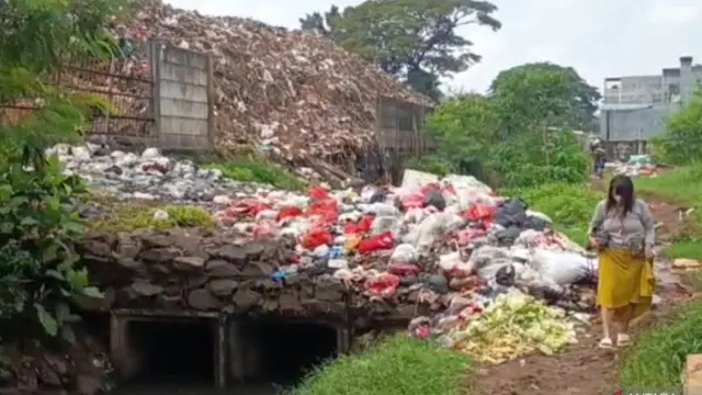 Tembok pembatas di TPS Pasar Induk Kramat Jati, Jakarta Timur roboh diduga akibat tekanan tumpukan sampah menggunung, Rabu (1/4/2026).