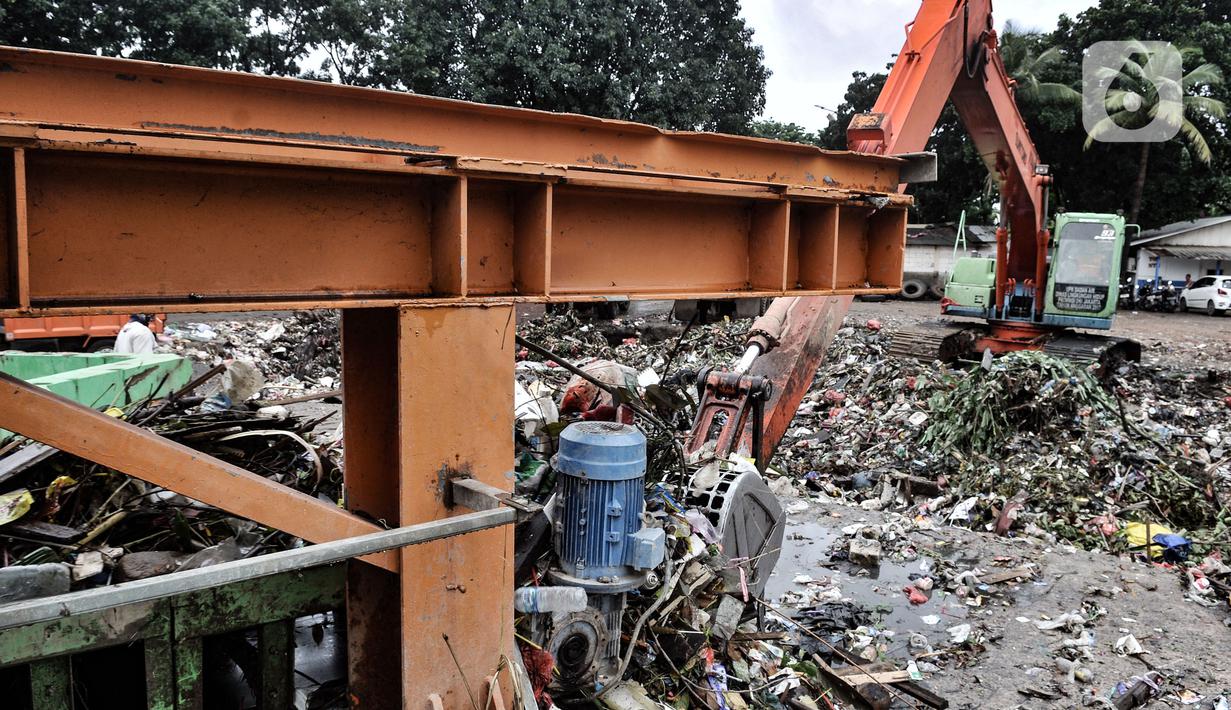 Petugas UPK Badan Air DLH Provinsi DKI Jakarta mengangkut sampah sungai memakai alat berat di TPSS Perintis Kemerdekaan, Jakarta, Selasa (16/2/2021). TPSS Perintis Kemerdekaan jadi penampungan sementara sampah sungai di Jakarta Timur, Selatan, Pusat, dan Kelapa Gading. (merdeka.com/Iqbal S. Nugroho)