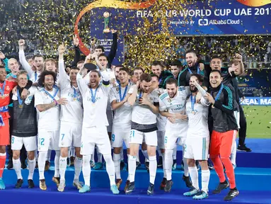Para pemain Real Madrid melakukan selebrasi mengangkat trofi Piala Dunia Antarklub 2017 di stadion Zayed Sports City di Abu Dhabi, Uni Emirat Arab, (16/12). Madrid sukses mengalahkan Gremio 1-0 berkat gol Cristiano Ronaldo. (AP Photo / Hassan Ammar)