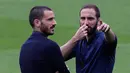 Penyerang Juventus, Gonzalo Higuain berbincang dengan bek Leonardo Bonucci di stadion Camp Nou, Barcelona, Spanyol, (18/4). Juventus akan bertanding melawan Barcelona di leg kedua perempat final Liga Champions. (AP Photo/Manu Fernandez)