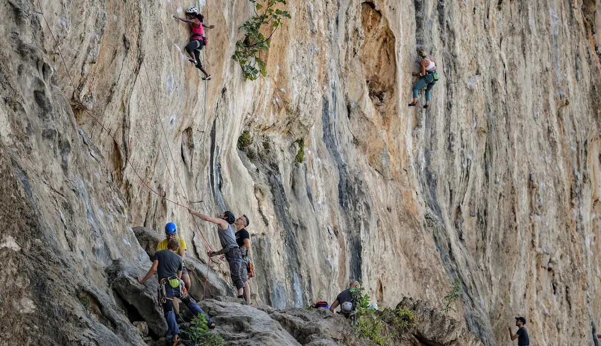 Peserta berusaha memanjat tebing dalam Festival Mendaki tahunan 2019 di pulau Kalymnos, Yunani (4/10/2019). Pemandangan menakjubkan dan cuaca bagus menjadikan pulau ini sebagai tujuan utama bagi pemanjat dari semua tingkatan dengan lebih dari 2500 rute pendakian. (AFP Photo/Aris Messinis)