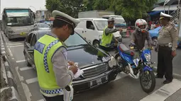 Polisi menilang pengendara kendaraan yang melewati jalur transjakarta ketika digelar Operasi Zebra 2014 di sekitar Pasar Senen, Jakarta, Rabu (26/11). Operasi tersebut menindak pengendara kendaraan yang melanggar aturan. (ANTARA FOTO/Saptono)