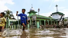 Bocah melintas di kawasan banjir di Perumahan Pondok Gede Permai (PGP) Jatiasih, Bekasi, Jawa Barat, Jumat (22/4). Ketinggian air mencapai 1,5 meter dari sebelumnya ketinggian mencapai hampir 4 meter. (Liputan6.com/Fery Pradolo)