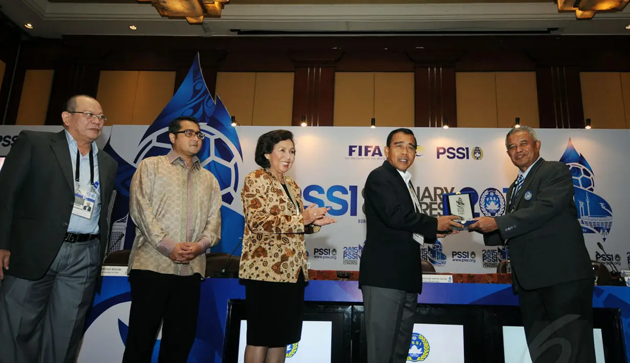 Ketua Umum PSSI, Djohar Arifin Husin (kanan) memberikan plakat kepada Ketua KONI Pusat, Tono Suratman (kedua dari kanan) usai membuka Kongres Tahunan PSSI di Hotel Borobudur, Jakarta (4/1/2015). (Liputan6.com/Helmi Fithriansyah)