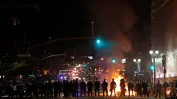 Petugas kepolisian membentuk barikade mengamankan aksi pengunjuk rasa yang membakar ban di tengah jalan Oakland, California, Rabu (9/11). Unjuk rasa merebak di seluruh wilayah Amerika Serikat, menyusul kemenangan Donald Trump. (REUTERS / Stephen Lam)