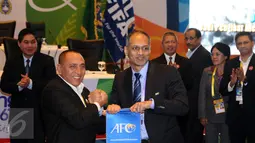 Edy Rahmayadi (kedua kiri) menerima plakat dari perwakilan AFC usai terpilih menjadi Ketua Umum PSSI pada kongres biasa di Jakarta, Kamis (10/11). Edy Rahmayadi meraih suara 76 dari 107 pemilik hak suara. (Liputan6.com/Helmi Fithriansyah)