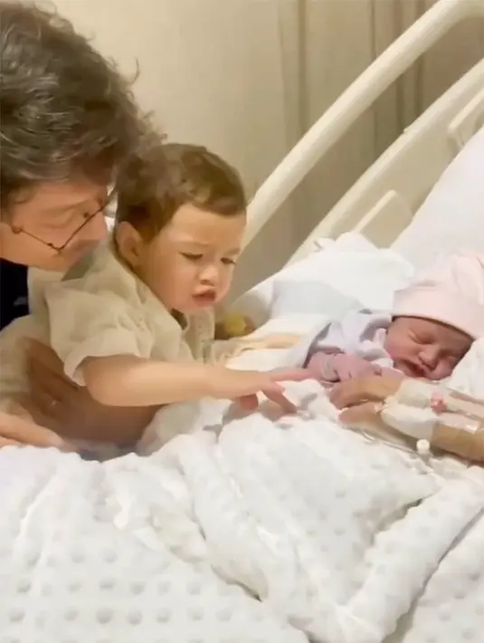 Djiwa menyapa sang adik yang tertidur pulas dalam gendongan sang mama. "Bobo," tanya Djiwa pada mamanya. [Instagram/dimsanggara]