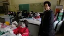 Tsukimi Ayano memeriksa boneka-bonekanya yang dipajang di sebuah sekolah dasar di desa kecil Nagoro, Jepang, 16 Maret 2019. Ayano menciptakan boneka-boneka tersebut dengan tongkat kayu, koran untuk mengisi tubuh, kain elastis untuk kulit dan wol rajut untuk rambut. (KAZUHIRO NOGI/AFP)