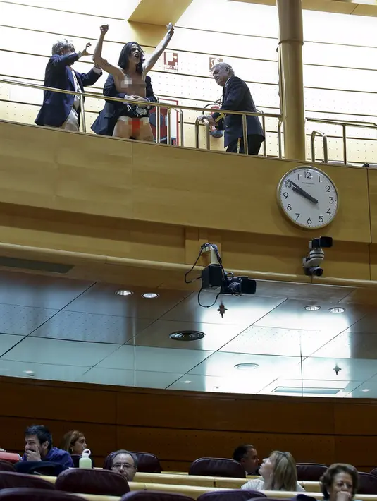 Aktivis Femen saat menghebohkan sidang parlemen di Madrid, Spanyol (9/9/2015). Coretan di tubuh bertuliskan "I decide", menolak rencana pembatasan aborsi untuk wanita di bawah 18 tahun. (REUTERS/Andrea Comas)