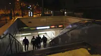 Polisi memasuki stasiun metro di Trocadero selama jam malam di Paris, Perancis, Selasa (15/12/2020). Tempat-tempat hiburan umum seperti teater, bioskop, museum, dan stadion sepak bola akan tetap ditutup selama tiga pekan lagi. (AP Photo/Francois Mori)
